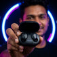 User holding CTRL8 A6S wireless earbuds in sleek black charging case with glowing neon backdrop